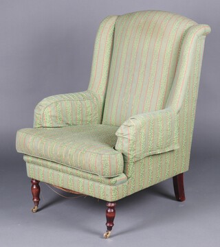 A Victorian style armchair upholstered in green and gold material 
