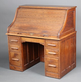 A 19th Century  roll top desk, the interior fitted pigeon holes, the base a brushing slide above 6 drawers 128cm h x 121cm w x 78cm d 