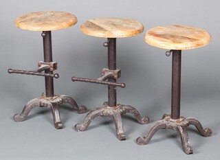 Three Victorian style iron stools with circular hardwood seats, raised on column and tripod base, 60cm h x 34cm diam
