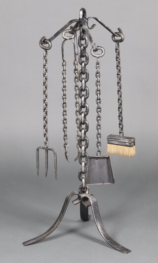 A wrought iron 4 piece fireside companion set with chain decoration comprising shovel, poker, tongs and brush on a cruciform base 89cm h 