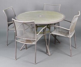 A circular pierced metal garden table 75h x 110 diam. together with 4 tubular metal stacking chairs