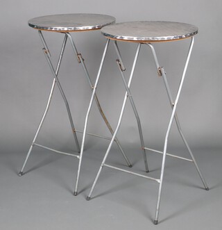 A pair of circular folding metal bar tables, raised on tubular supports, 112cm h x 59cm (some rust in places)