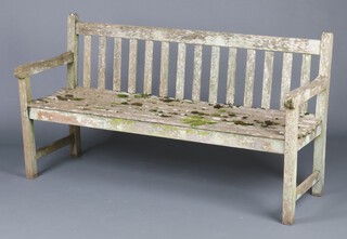 A well weathered wooden slatted garden bench 84cm h x 152cm w x 53cm d 