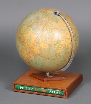 A Phillips 1961 terrestrial globe on a wooden stand, the base fitted a Phillips Record Atlas 
