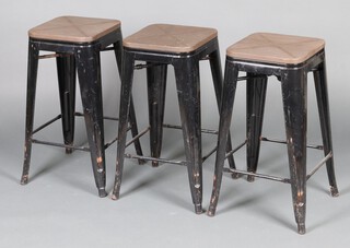 Three black painted pressed metal and pine stacking stools with painted brown seats,  66cm h x 30cm w x 30cm d 
