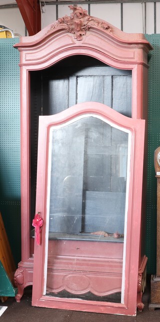 A 19th Century French carved and red painted armoire, the interior fitted shelves enclosed by an arched panelled door, the base fitted a drawer 240cm h x 105cm w x 50cm d 