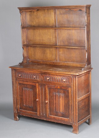 An oak dresser, the raised back with moulded cornice, the base fitted 2 drawers above double cupboard 176cm h x 121cm w x 46cm d (water and contact marks in places) 