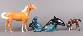 A Beswick figure of a standing Palomino horse 21cm, Beswick figure of a foal, Poole Pottery dolphin and ditto otter 
