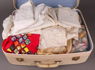 A 1950's vintage suitcase containing a collection of linen, cotton reels etc 
