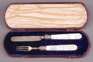A Victorian 2 piece cased christening set with knife and fork having silver blade and mother of pearl handles 