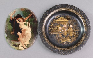 An oval concave painting on glass, study of a boy and girl on swing 14cm x 10cm together with a circular black and gilt lacquer tray 16cm 