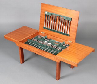A 53 piece Viners Studio pattern canteen of chromium plated flatware - 6 table knives, 6 forks, 6 tea knives, 6 fish knives, 6 forks, serving spoon and fork, 2 serving spoons, 6 tea spoons, 6 spoons, 6 soup spoons, 6 forks, all contained in a rectangular teak coffee table with hinged lid, raised on square supports 37cm h x 119cm w x 44cm d 