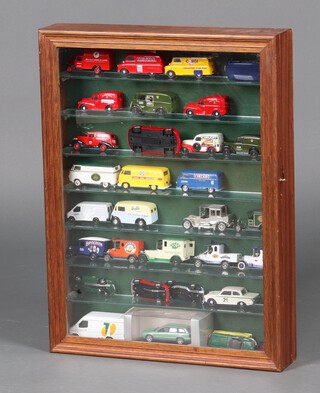 A wooden and glass framed display case fitted glass shelves full of Modern Days Gone and other model cars 