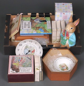 A Wedgwood Beatrix Potter wall clock (hands a/f), a figure of Peter Rabbit, a Beatrix Potter floor puzzle, books and other Beatrix Potter related items