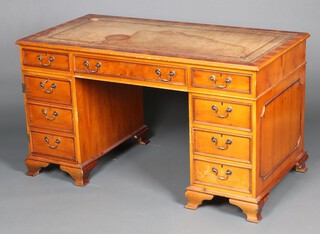 A yew pedestal desk with brown inset writing surface, fitted a recess flanked by 2 drawers, the pedestals fitted dummy drawers and 3 long drawers, raised on bracket feet 76cm h x 138cm w x 71cm d (staining to writing surface) 