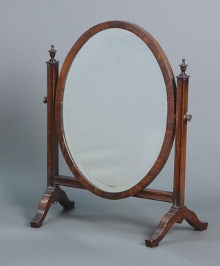 A 1930's oval bevelled plate dressing table mirror contained in an oak swing frame 54h x 39w x 23d 