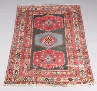 A black red and blue ground Caucasian style rug with 3 stylised medallions to the centre within a multi row border 160cm x 114cm 