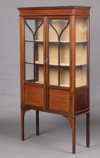 An Edwardian inlaid mahogany display cabinet fitted shelves enclosed by astragal glazed panelled doors, on square tapered supports 167cm h x 89cm w x 32cm d 