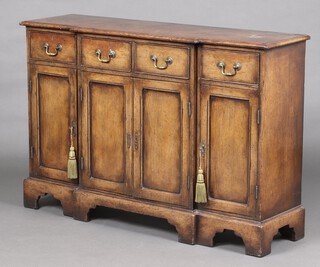 A 17th Century style inverted breakfront oak dresser base, fitted 2 short drawers above double cupboards enclosed by pair of panelled doors, flanked by 2 drawers above cupboards, raised on bracket feet 84cm h x 126cm w x 36cm d 