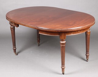 An Edwardian oval Georgian style extending dining table with 1 extra leaf, raised on turned and reeded supports with brass caps and ceramics casters  75cm h x 106cm w x 150cm l 