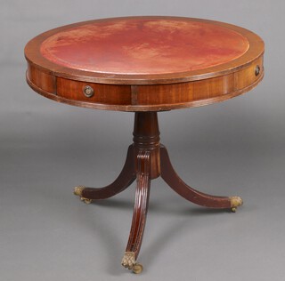 A Georgian style circular drum table with red leather inset writing surface, fitted 4 drawers, raised on turned column and tripod base with brass paw caps 79cm h x 91cm diam. 