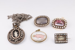 A yellow metal and demi-pearl set oval mourning brooch with hair panel to the centre 2.5cm, 1 other 2cm, rectangular ditto 1.5cm, a white metal oval pendant with hair panel to the reverse 4cm hung on a metal chain and a gilt metal circular pendant2.5cm