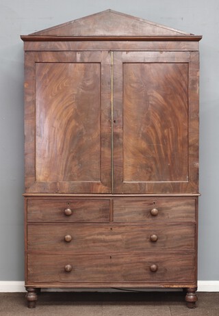 A 19th Century mahogany linen press, the upper section with moulded cornice, the interior fitted 5 trays enclosed by panelled doors, the base fitted 2 short and 2 long drawers with turned handles, raised on turned supports 224cm h x 131cm w x 57cm d 