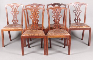 A set of 6 1920's Chippendale style mahogany slat back dining chairs with embossed leather drop in seats, raised on square supports 
