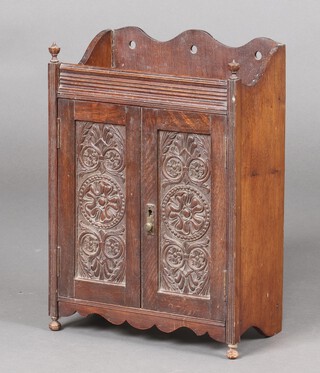A Victorian carved oak smokers cabinet, the interior fitted 2 drawers, recess and pipe rack, raised on bun feet 45cm h x 33cm w x 17cm d 