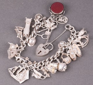 A silver charm bracelet hung numerous charms and wth padlock clasp, 18cm, 77g