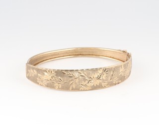 An engraved gold bangle marked 375, 6.5cm wide, 9.5g