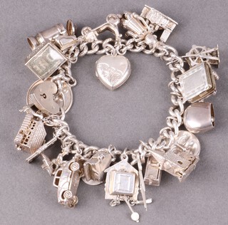 A silver charm bracelet hung numerous charms and wth padlock clasp, 18cm, 94g