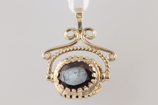A gold marked 375 swivel pendant set red stones, 5.2g