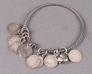 A metal bangle hung a George III silver threepence, 9 other coins and a charm 