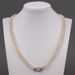 A double string of Mike cultured pearls with white metal clasp marked 14ct, 52cm 