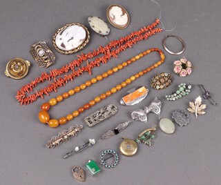 A shell carved cameo portrait brooch, a pierced silver filigree bow shaped brooch and other brooches 