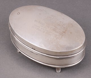An oval silver trinket box with hinged lid, raised on panelled supports Birmingham 1921, 5cm x 13cm x 7cm monogrammed, marks rubbed 