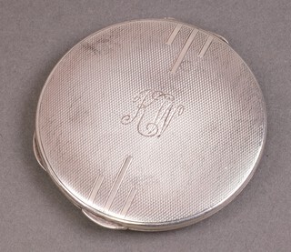 A circular silver compact with engine turned decoration, monogrammed,  Birmingham 1936, 59g 