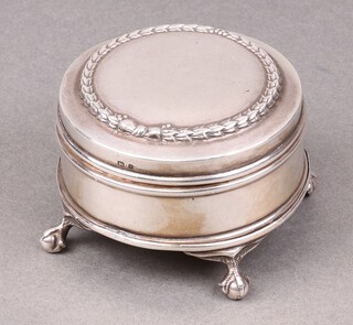 A circular silver trinket box with hinged lid, the interior fitted a mirror and plush lining, on cabriole claw and ball supports, Birmingham 1906 6.5cm diam. 