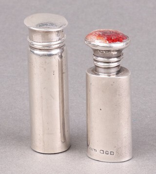 A cylindrical glass and silver scent phial London 1919 with original glass applicator 6cm (dents throughout) and an oval ditto with enamelled lid London 1927 7cm (with replacement plastic applicator, enamelled lid damaged, dented in places) 