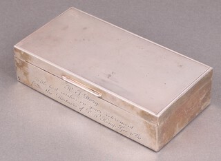 A rectangular silver cigarette box with engine turned decoration and inscription  "H J Story with best wishes on your retirement from Partners of R N Kemp - G & Co." Birmingham 1970 4cm h x 17cm w x 9cm d 