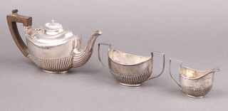 A Victorian 3 piece bachelor's oval tea service with demi-reeded decoration comprising teapot, milk jug and twin handled sugar bowl, Birmingham 1898 by Henry Bourne, 303g