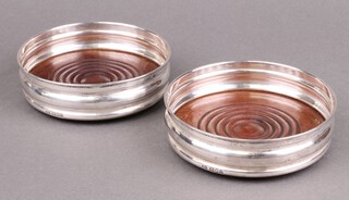 A pair of silver and mahogany wine bottle coasters London 1978 by Noreen Farr, 13cm diam. 