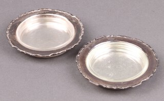 A pair of circular silver butter dishes with clear glass liners London 1937 by Harrods Ltd., 144g 