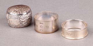 An embossed silver napkin ring Birmingham 1900 monogrammed, a silver napkin ring Birmingham 1977 with Jubilee hallmark and 1 other silver napkin ring, 57g 