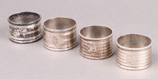 A pair of silver napkin rings with engine turned decoration, monogrammed,  Birmingham 1914 by Edward Souter Barnsley, together with two silver napkin rings Birmingham 1915 and 1938, 137g 