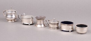 An oval silver mustard pot and matching salt  on bun feet, London 1936, a silver mustard pot (lid f), a silver salt (no liner), a pierced silver mustard pot (no liner), 1 other with plastic liner and a silver salt spoon, 101g  