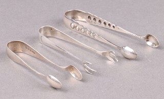 A pair of silver sugar tongs Sheffield 1956, a pair of silver Old English pattern ditto Birmingham 1911 and a pair of Sterling ditto monogrammed, 49g 