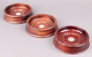 Three mahogany and silver circular bottle coasters London 1991 by Garrards and Company Ltd., 14cm 
