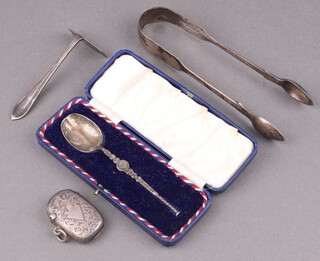 A pair of Victorian silver fiddle pattern sugar tongs London 1840, engraved silver vest case Birmingham 1901, silver model of the anointing spoon Birmingham 1936, 80g together with a child's silver plated pusher  